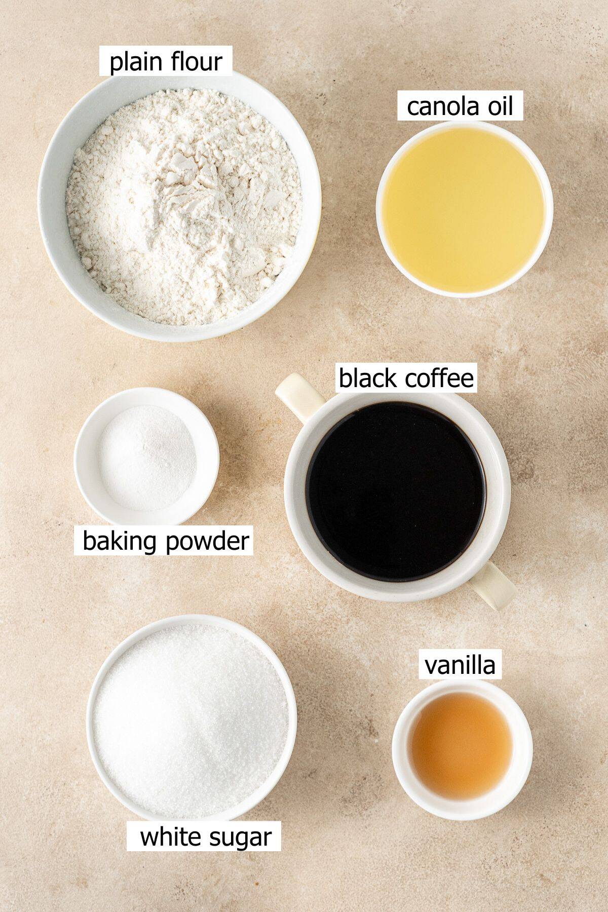 All ingredients needed to make a coffee flavoured cake laid out in small bowls.