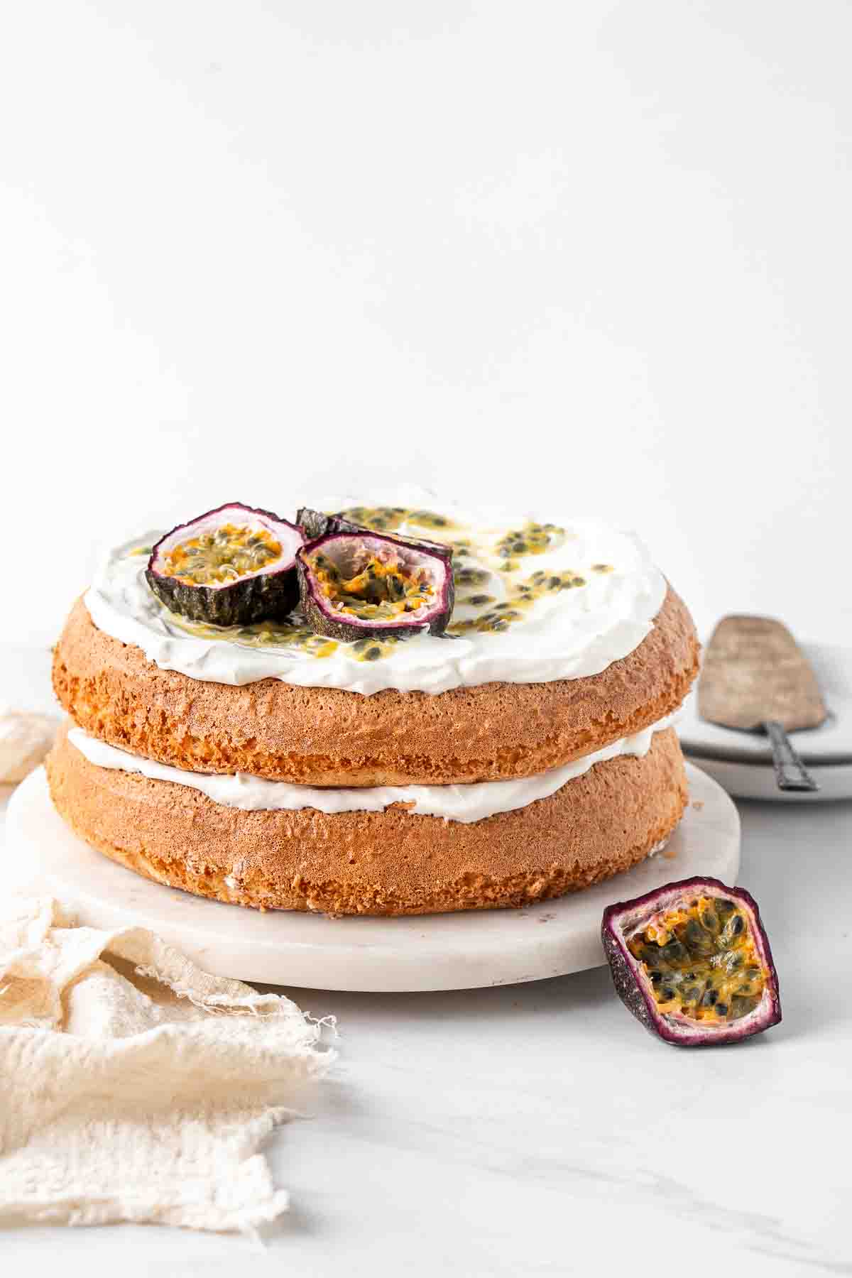 Dairy free passionfruit sponge cake topped with fresh passionfruit and whipped cream.