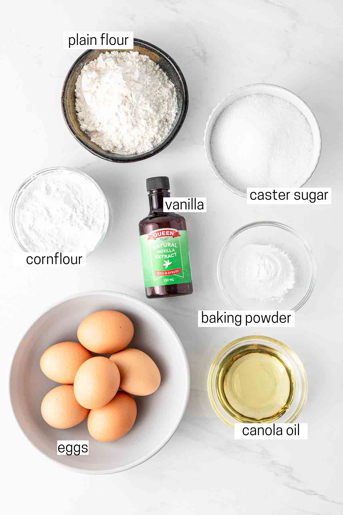 All ingredients needed for the sponge cake laid out in bowls.