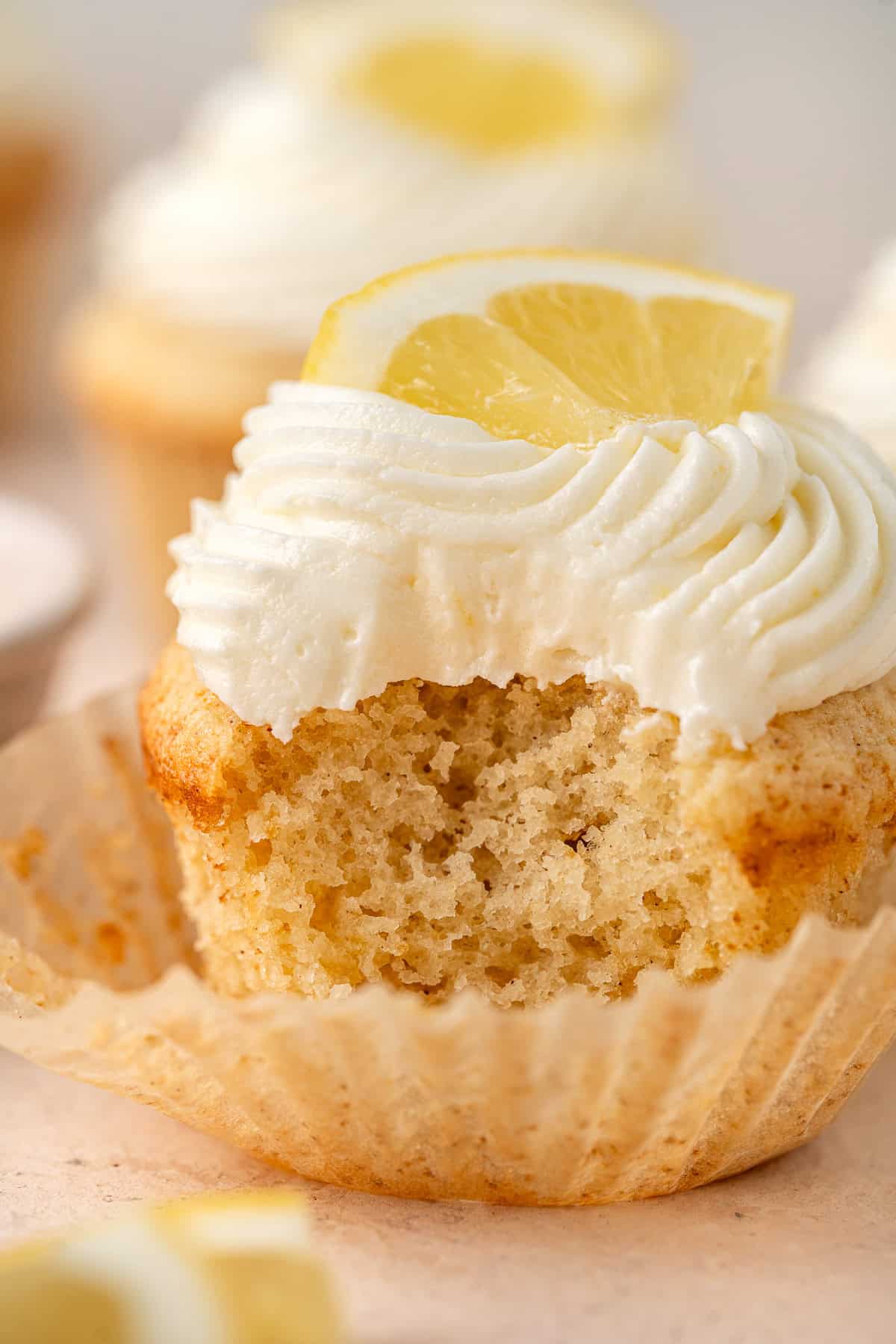 Close up of a lemon cupcake with a bite taken.