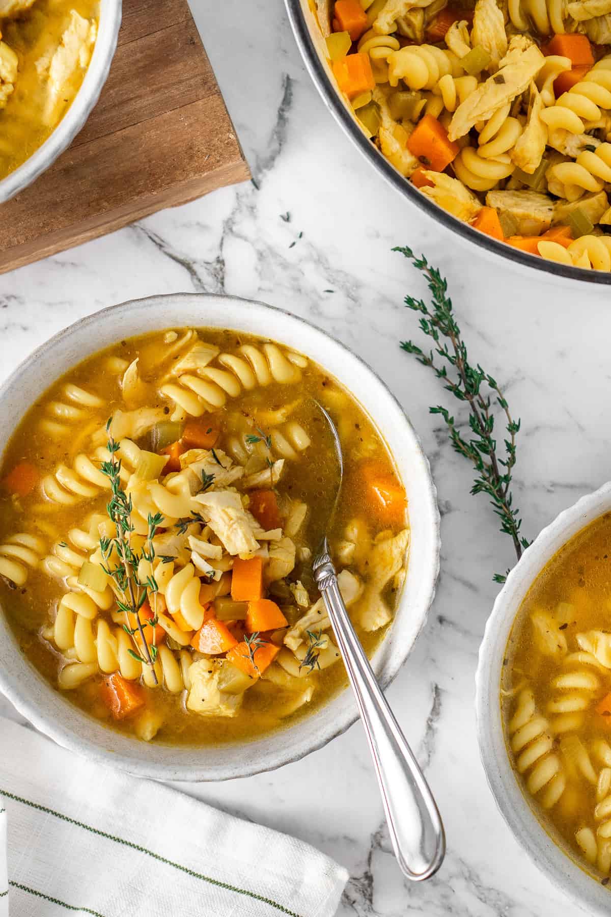 Close up of chicken soup in bowls with a spoon.