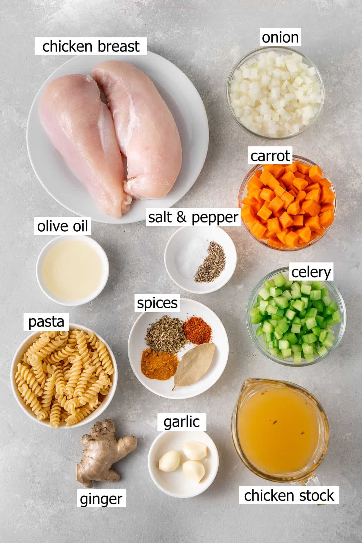 All ingredients needed to make healing chicken soup laid out in bowls.