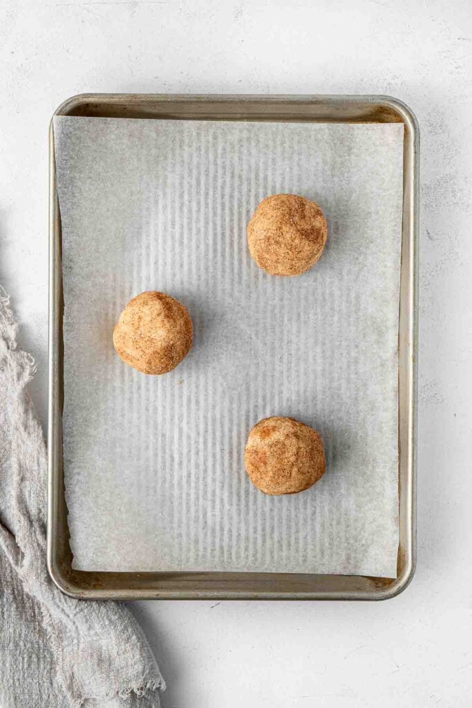Balls of dough spaced out on a baking tray.