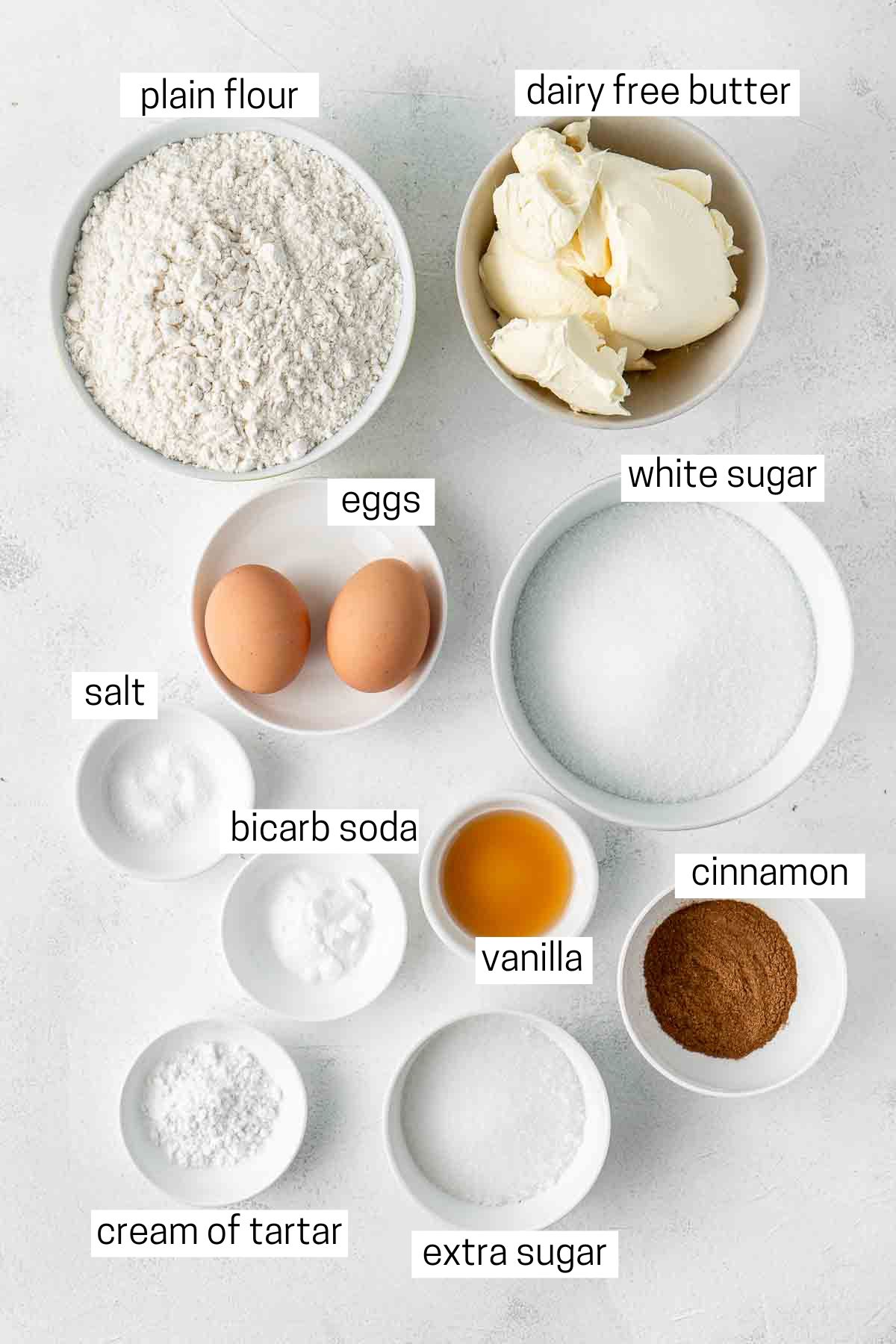 All ingredients needed for snickerdoodles laid out in small bowls.