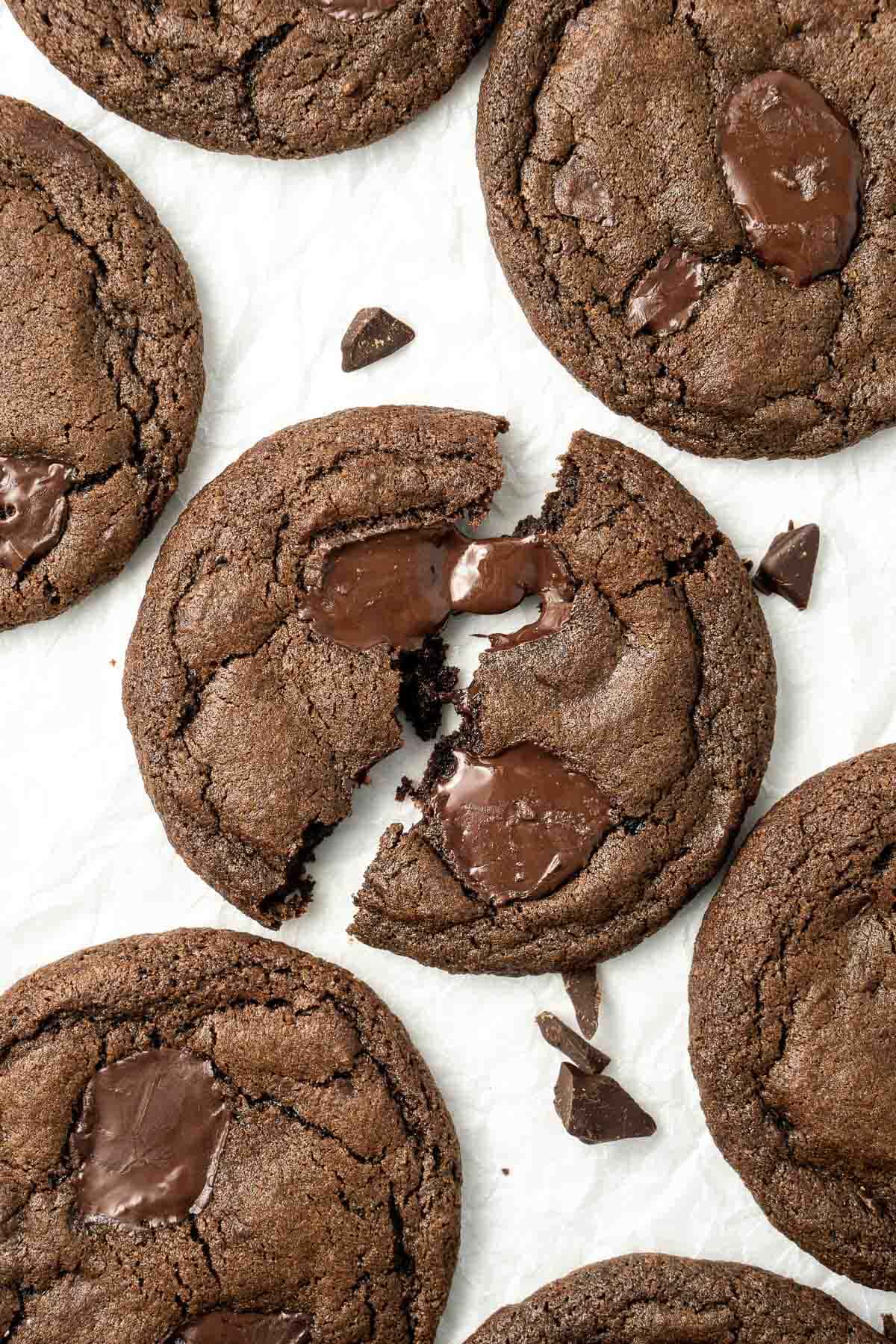 Close up of a dark chocolate chunk cookie broken in half with melted chocolate. 