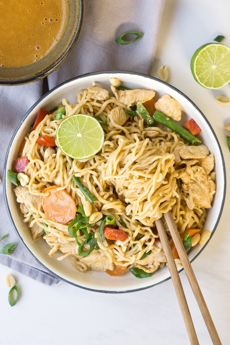 chicken satay noodles in bowl with chopsticks 