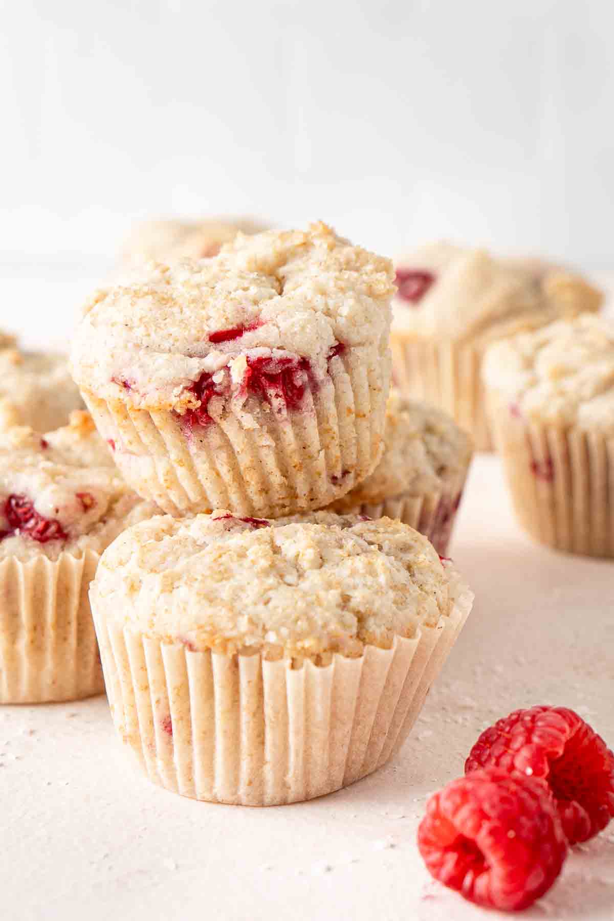 Vegan raspberry muffins stacked on top of each other.
