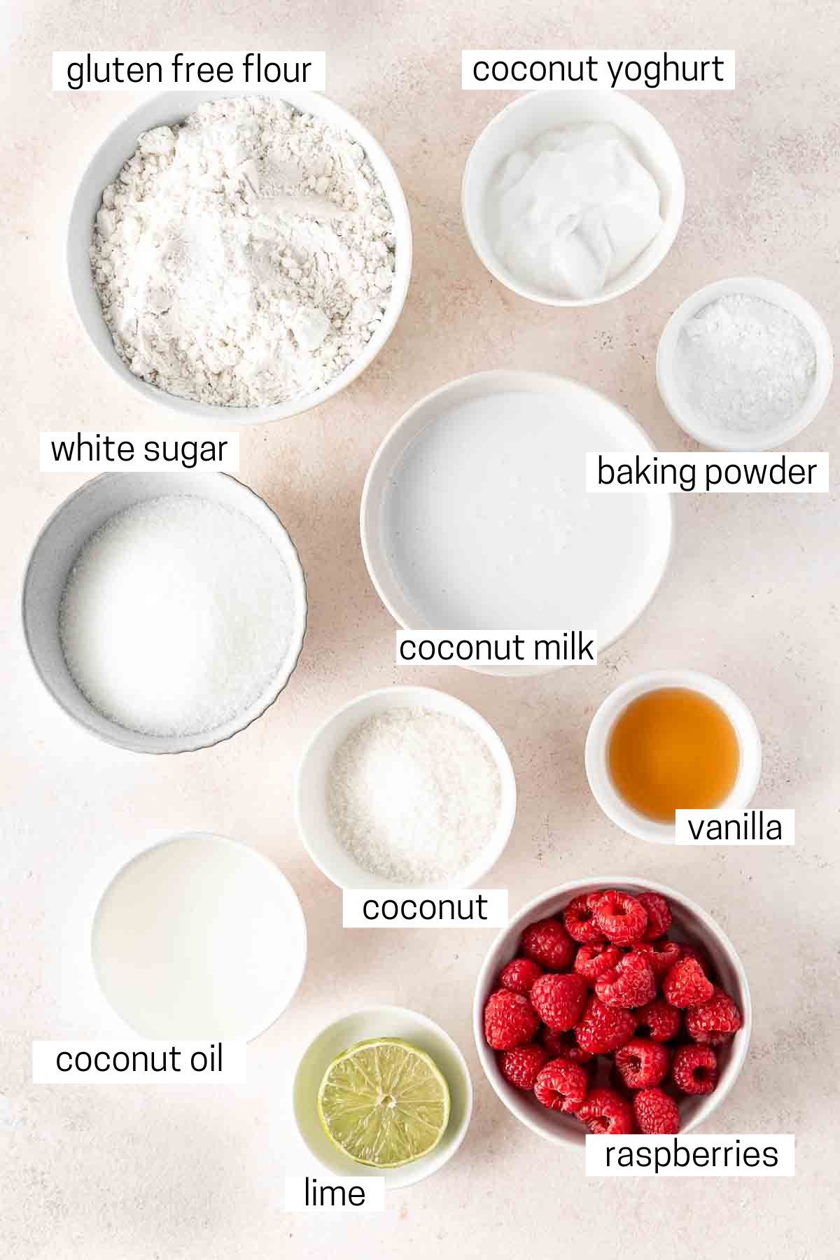 All ingredients needed to make raspberry coconut muffins laid out in small bowls.