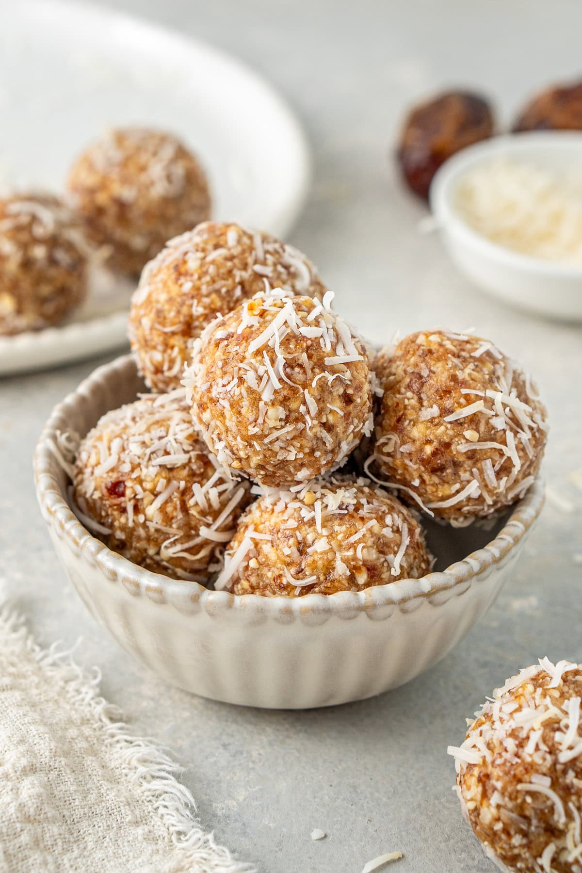 Peanut butter bliss balls in a bowl coated in coconut.
