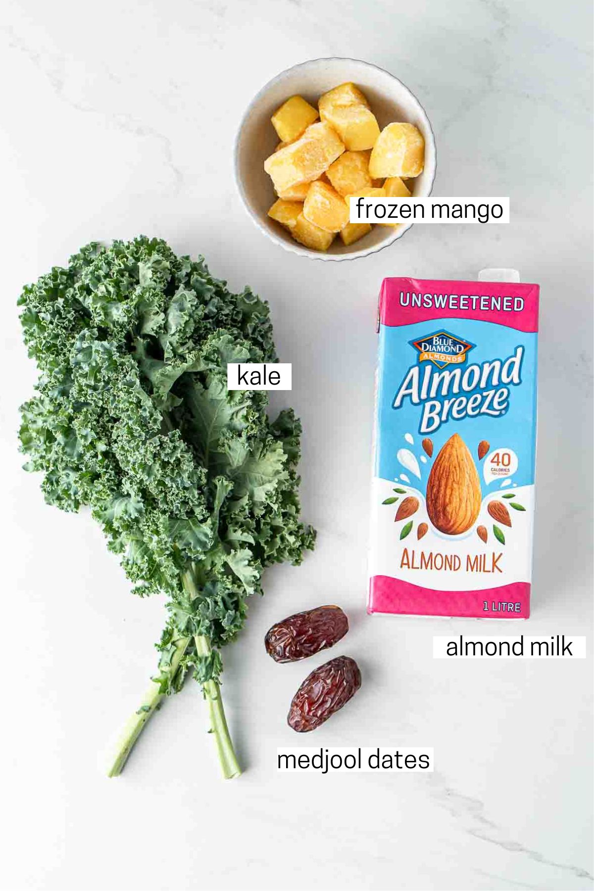 All ingredients for a mango kale smoothie laid out.