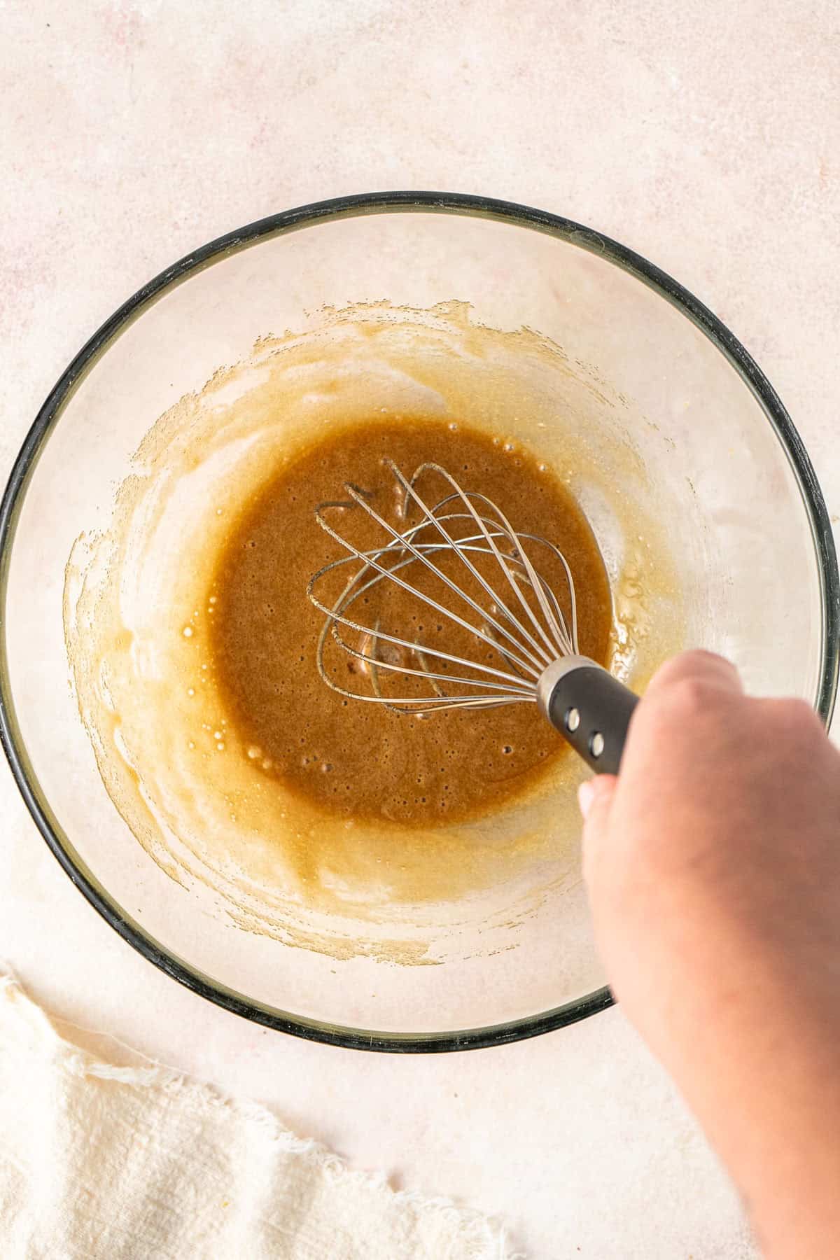 Whisking together the egg and sugar in a glass bowl.