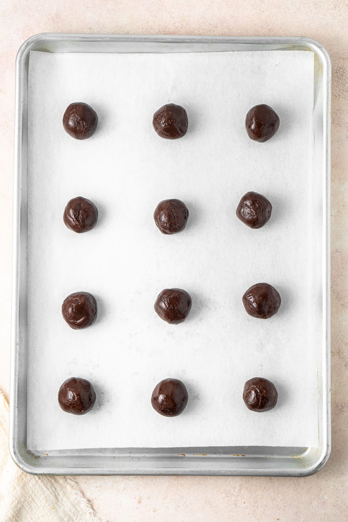 Tablespoons of dough in balls on a baking tray.