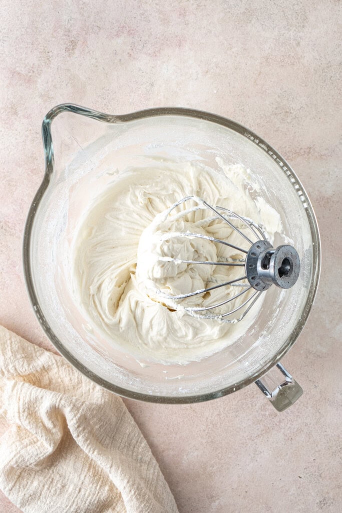The dairy free buttercream in a bowl with a whisk attachment. 