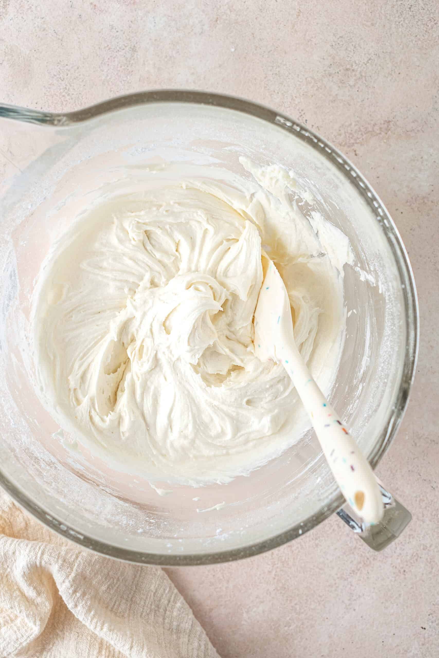 The creamy dairy free buttercream in a bowl with a spatula.