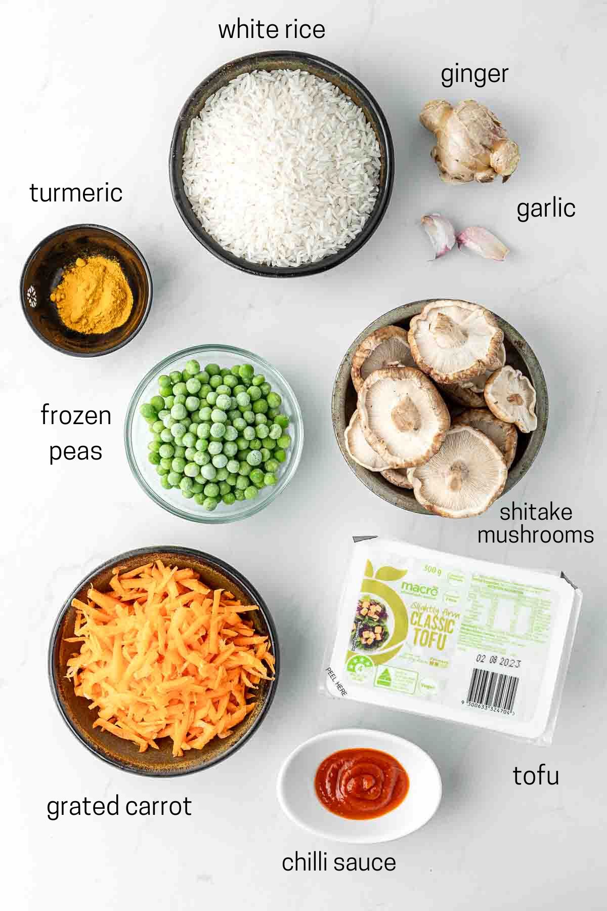 All ingredients needed to make turmeric fried rice laid out in bowls.