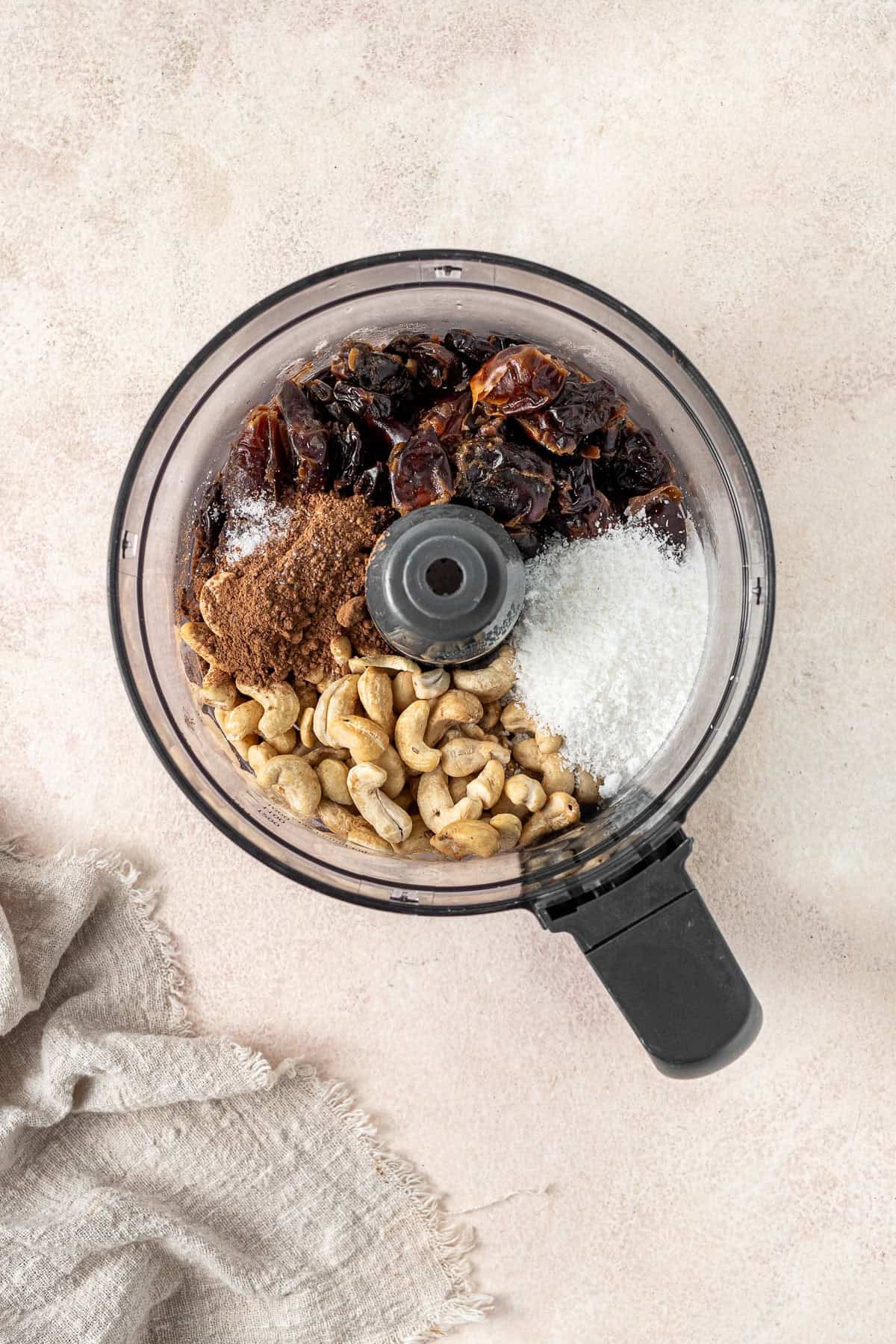 All ingredients to make cherry ripe bliss balls in a food processor.