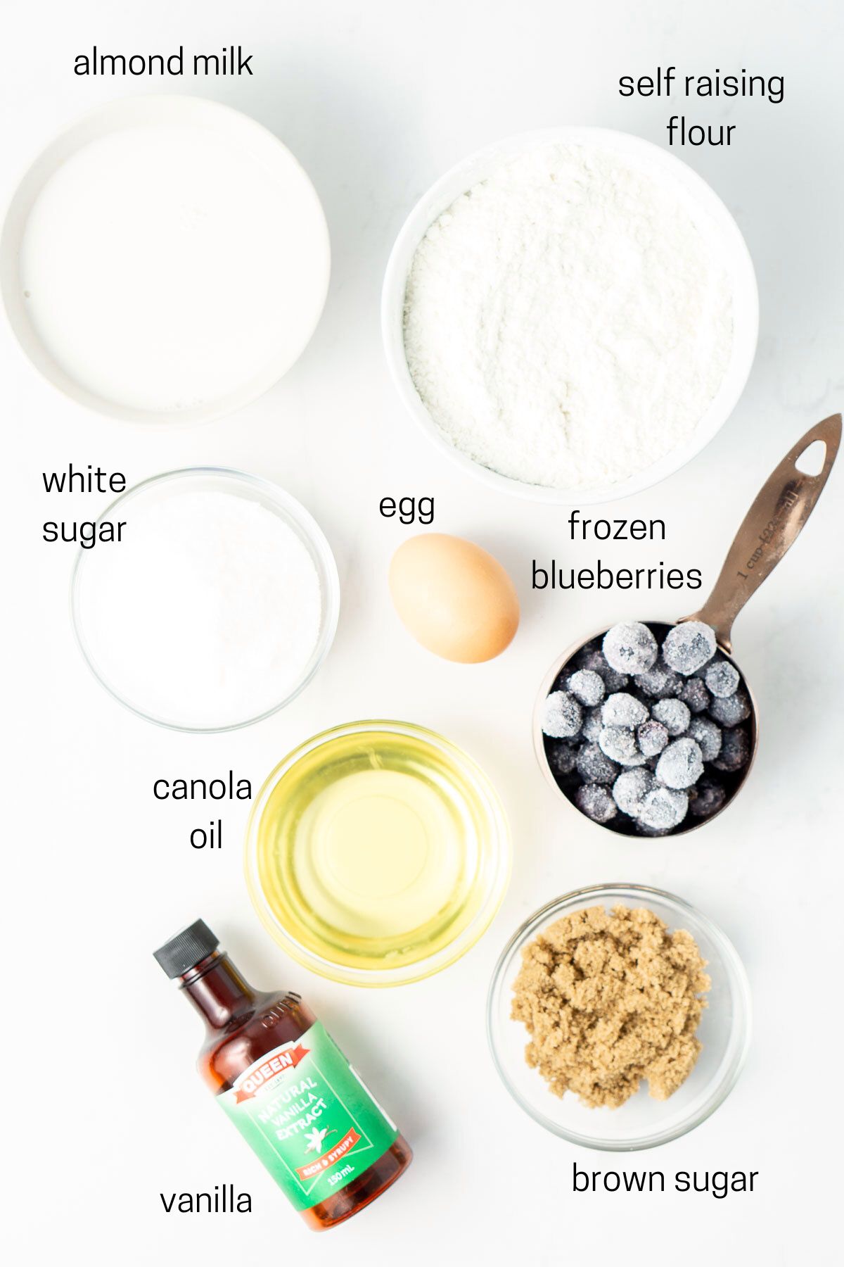 all ingredients needed for blueberry muffins laid out in small bowls.