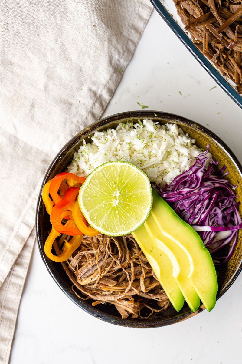 Close up of beef burrito bowls with avocado and lime