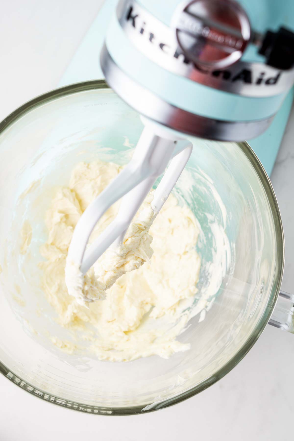 Butter and vanilla being beaten together in a stand mixer.