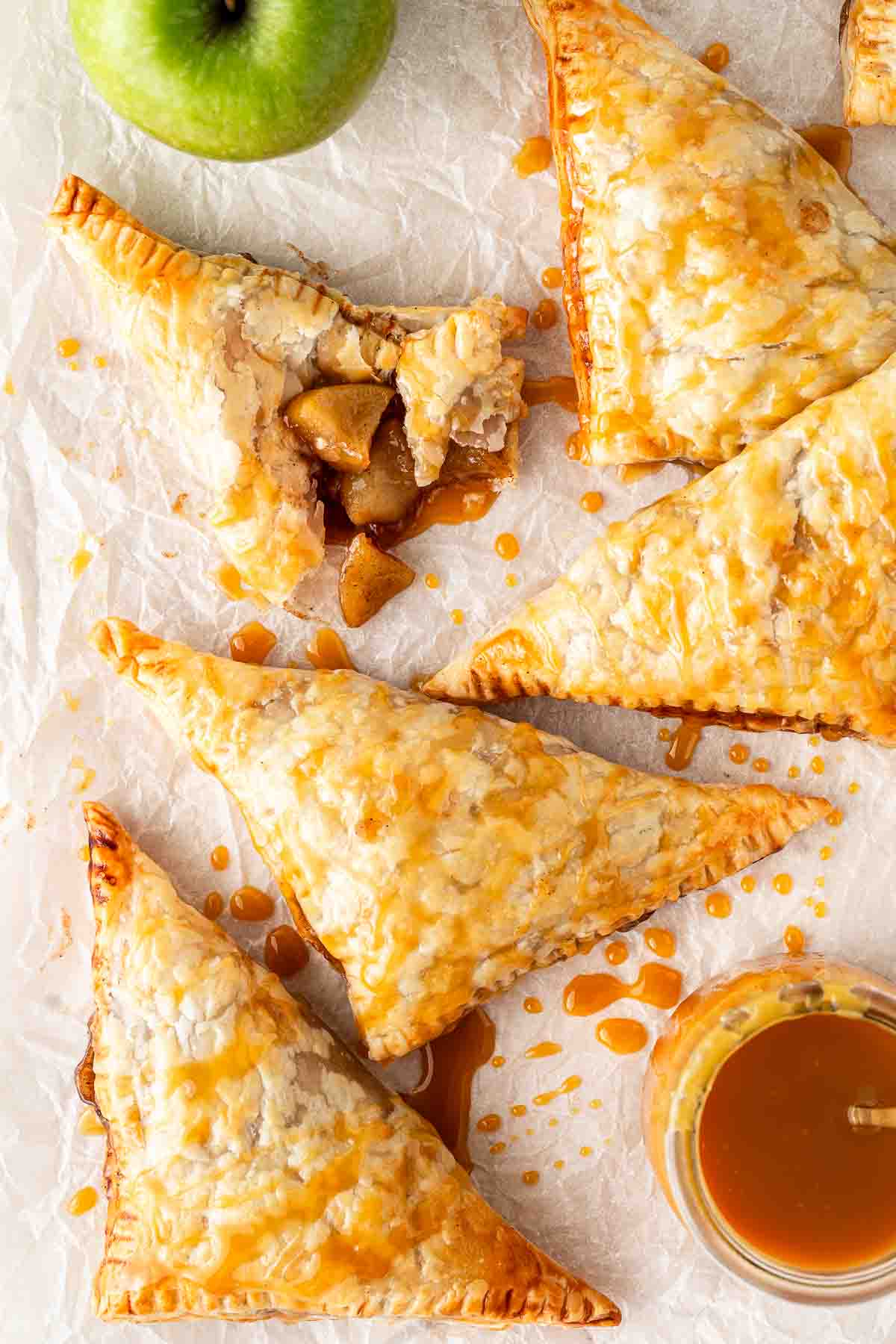 Apple turnovers laid out with salted caramel sauce drizzle.