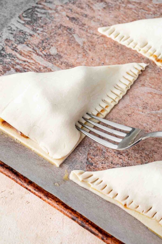Sealing apple turnovers with a fork.