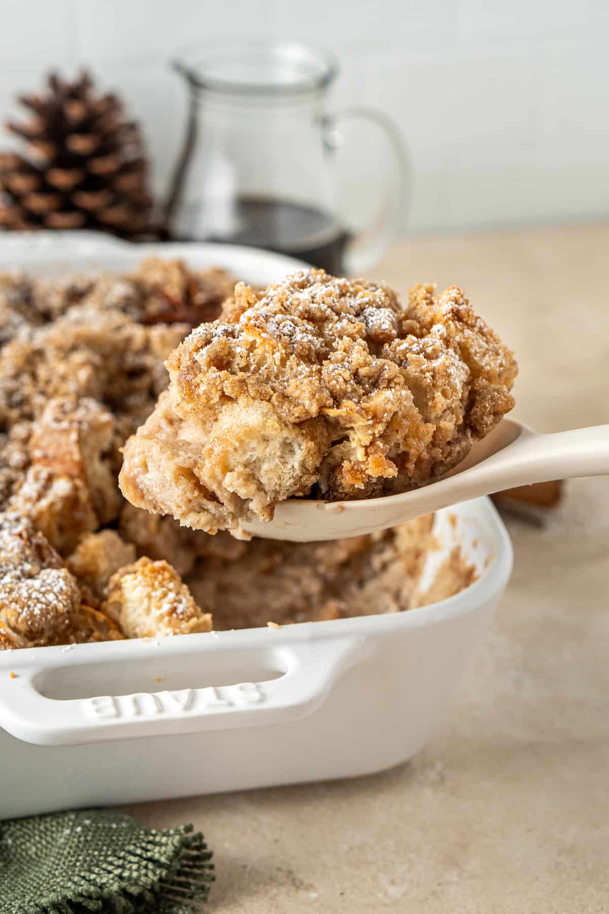 A spoon serving up a slice of the French toast. 