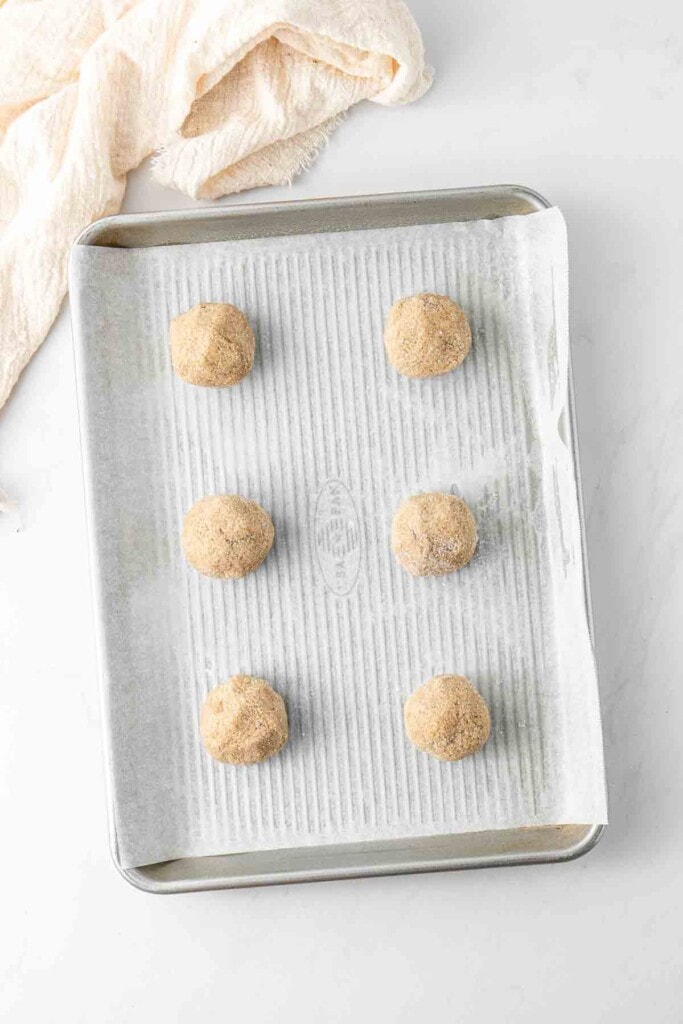 Balls of biscuit dough placed on baking tray for baking.