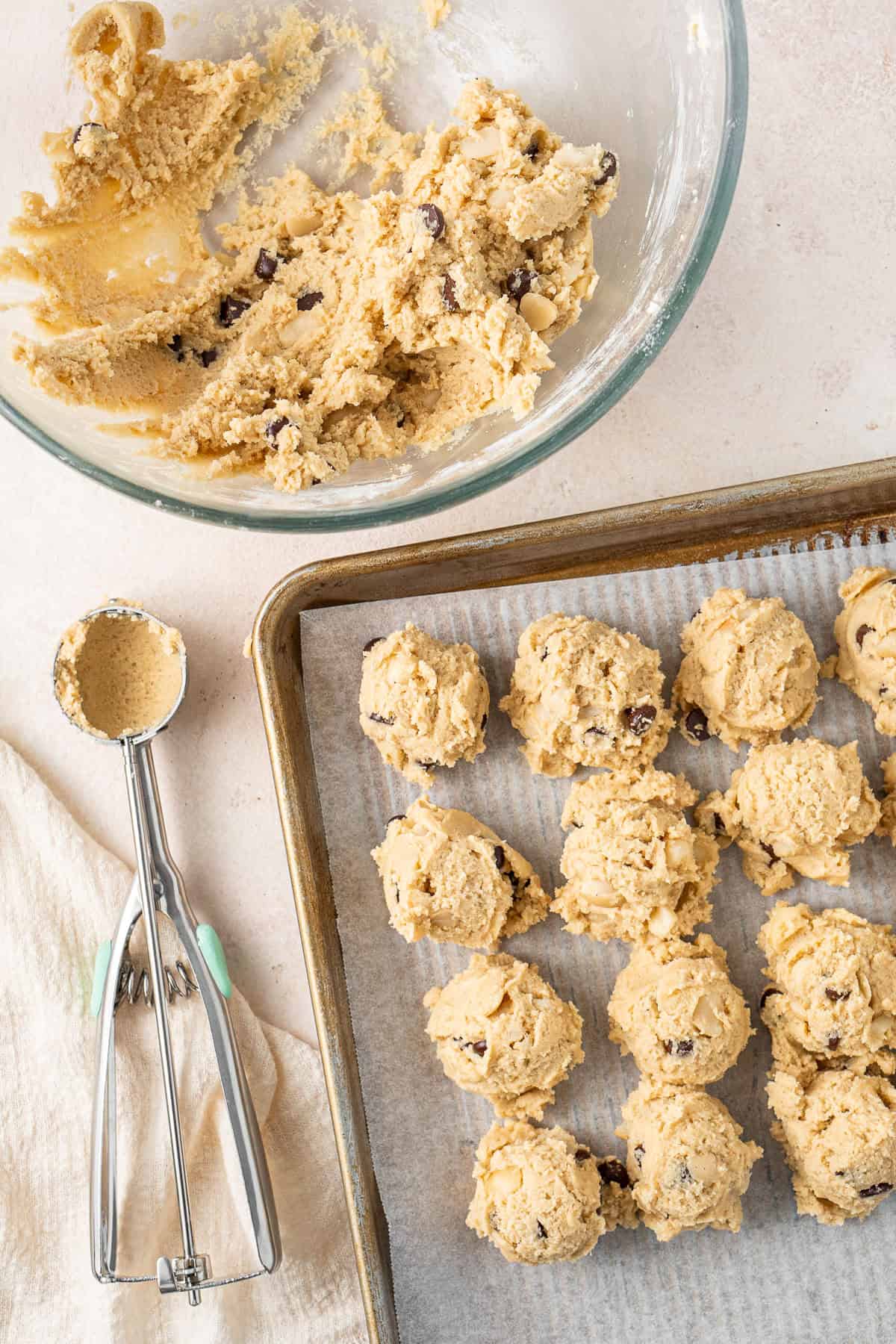 Scooping balls of dough with a cookies scoop.
