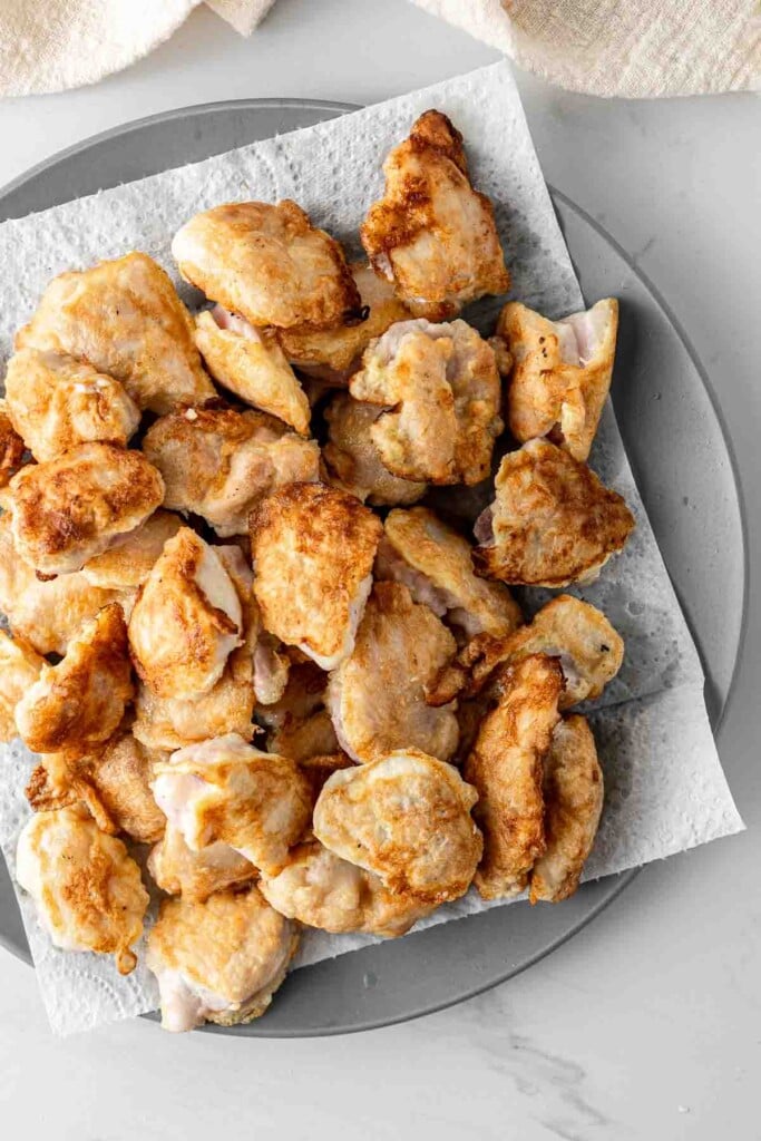 Cooked chicken pieces on a plate.