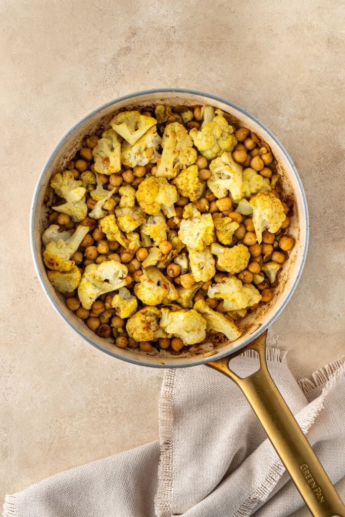 Cooking the cauliflower and chickpeas in the pan.