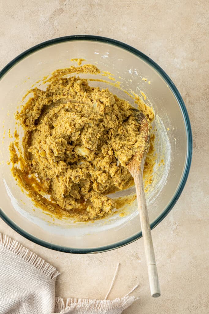 Mixing up the patty mixture in a bowl with a wooden spoon.