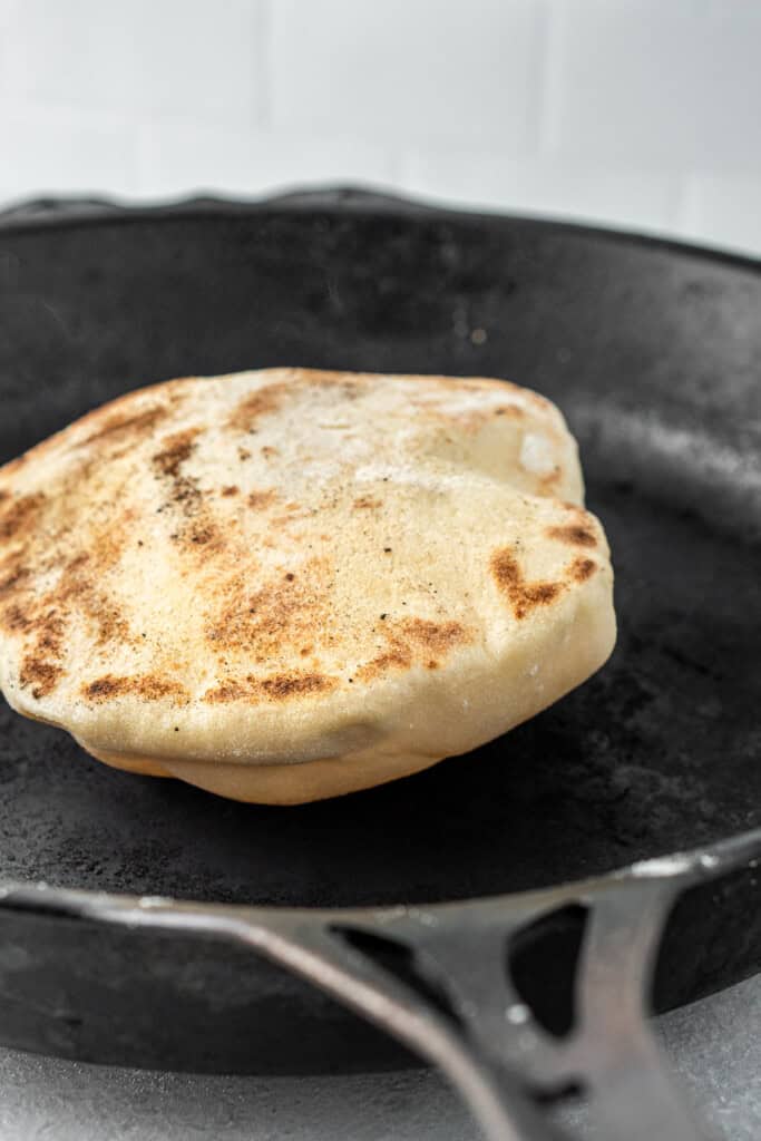 The pita puffing up in the cast iron pan.