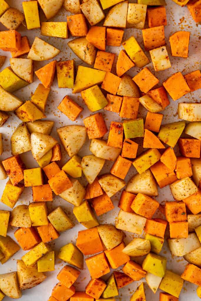 Close up of the potato, sweet potato and pumpkin on a baking tray.