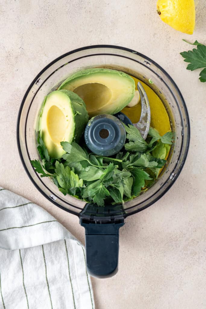 All ingredients for the green goddess sauce in a food processor.