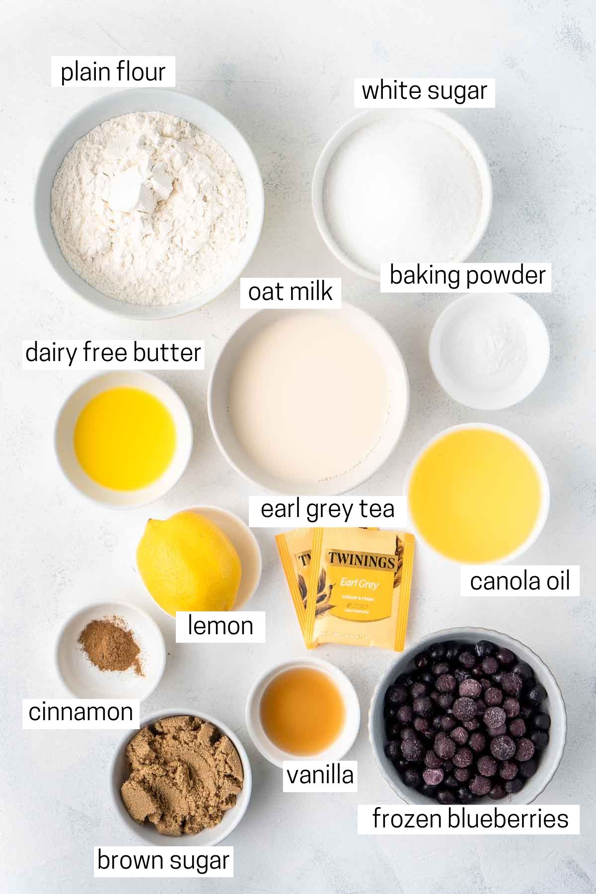 All ingredients needed to make blueberry earl grey muffins laid out in bowls.