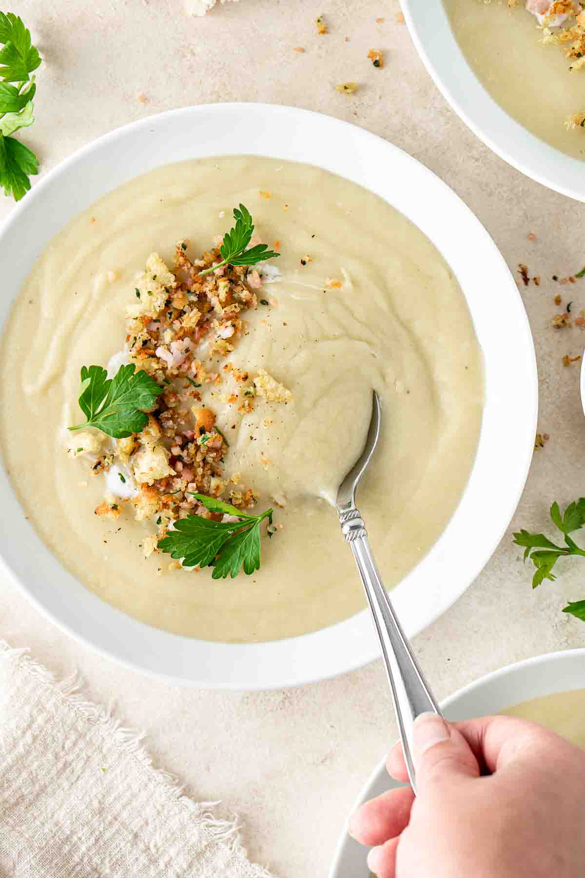 A spoon taking a bite of potato and leek soup.