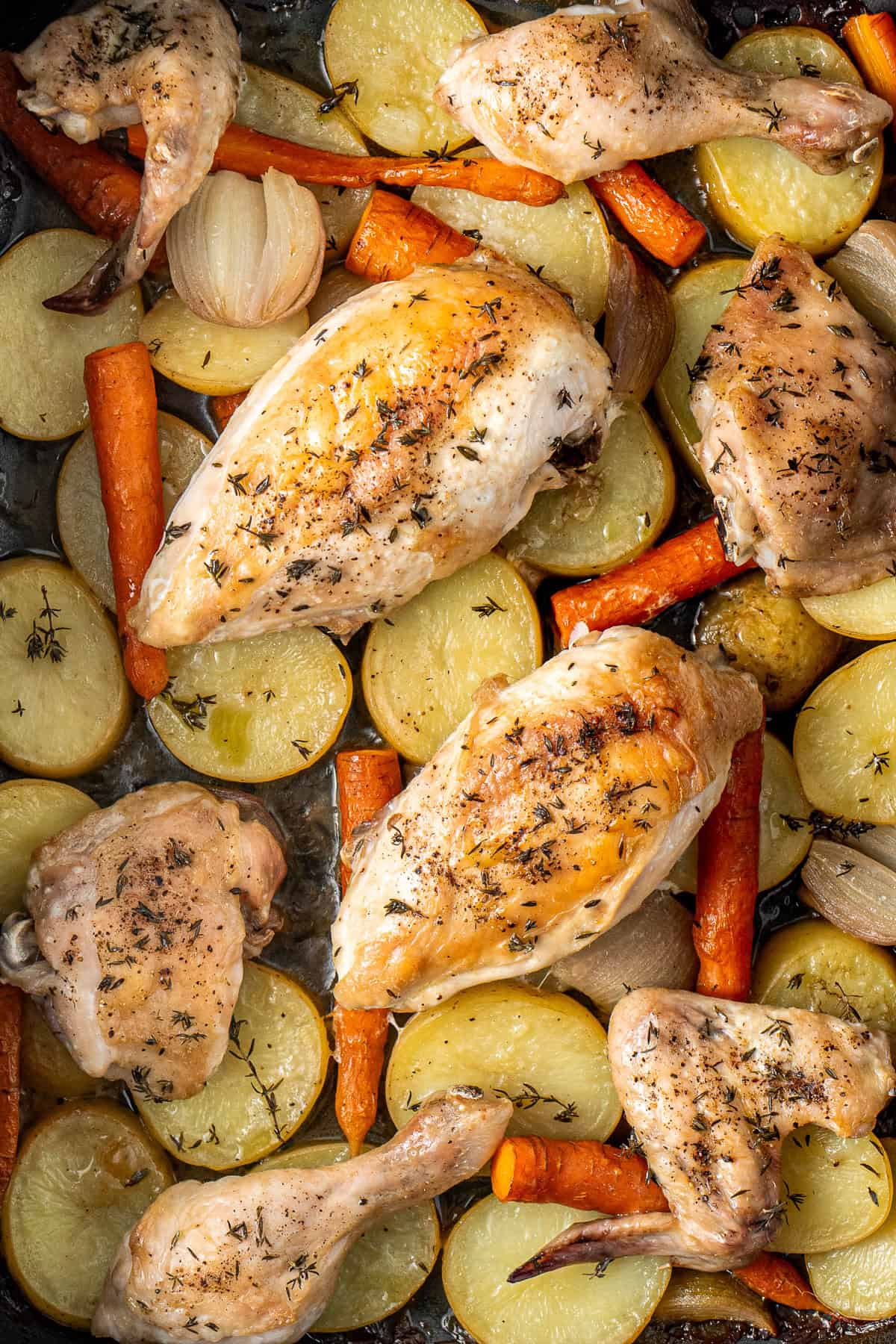 The cooked chicken and vegetables in a baking tray.