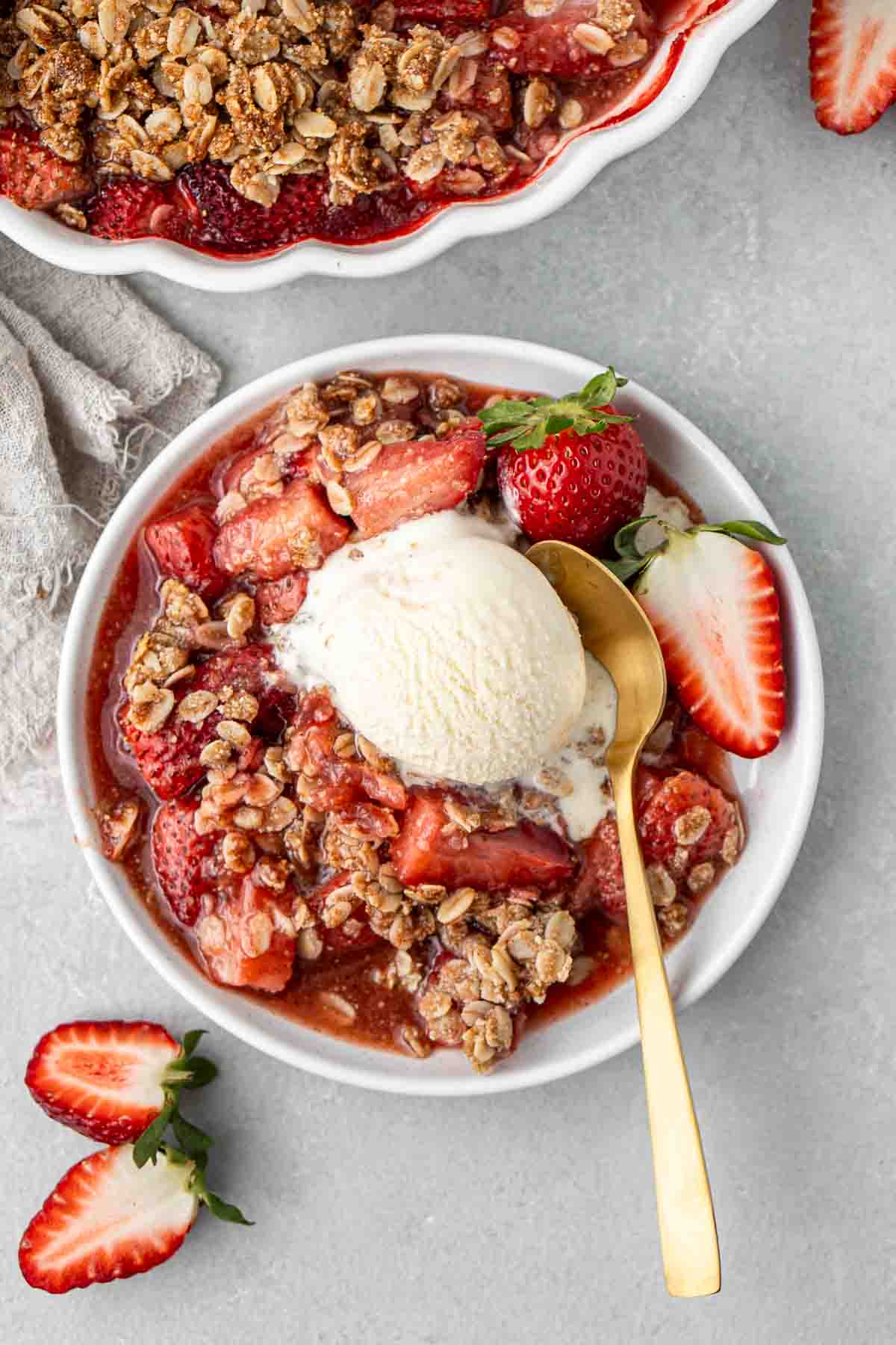 Close up of a plate of strawberry crisp with vanilla icecream.