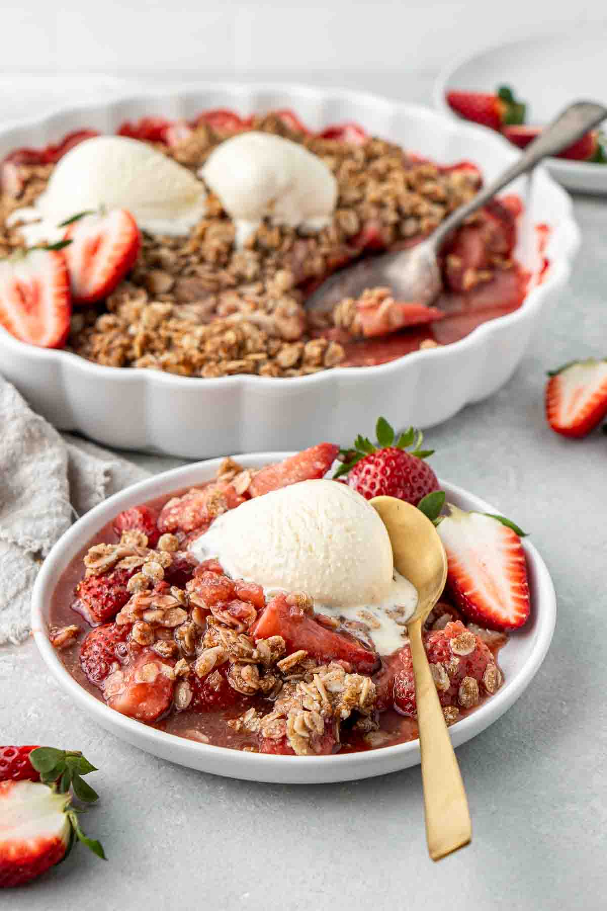 A plate of strawberry crumble with vanilla ice cream.