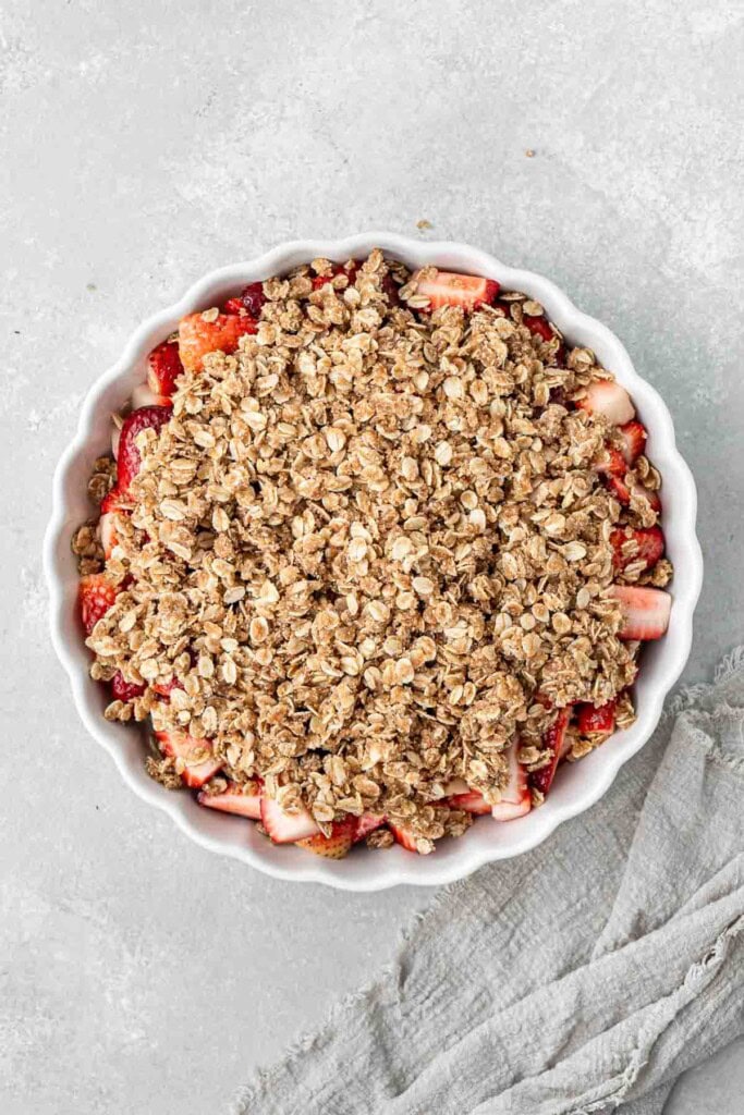 Strawberry crumble in a dish ready to bake.