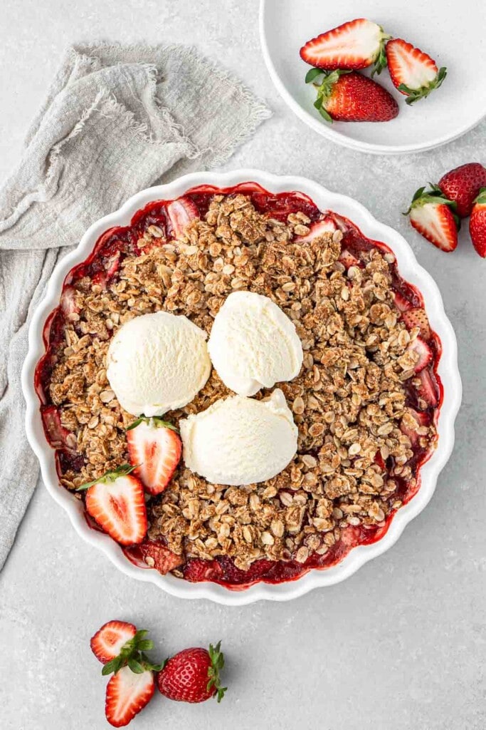 Strawberry crumble cooked and served with ice cream.