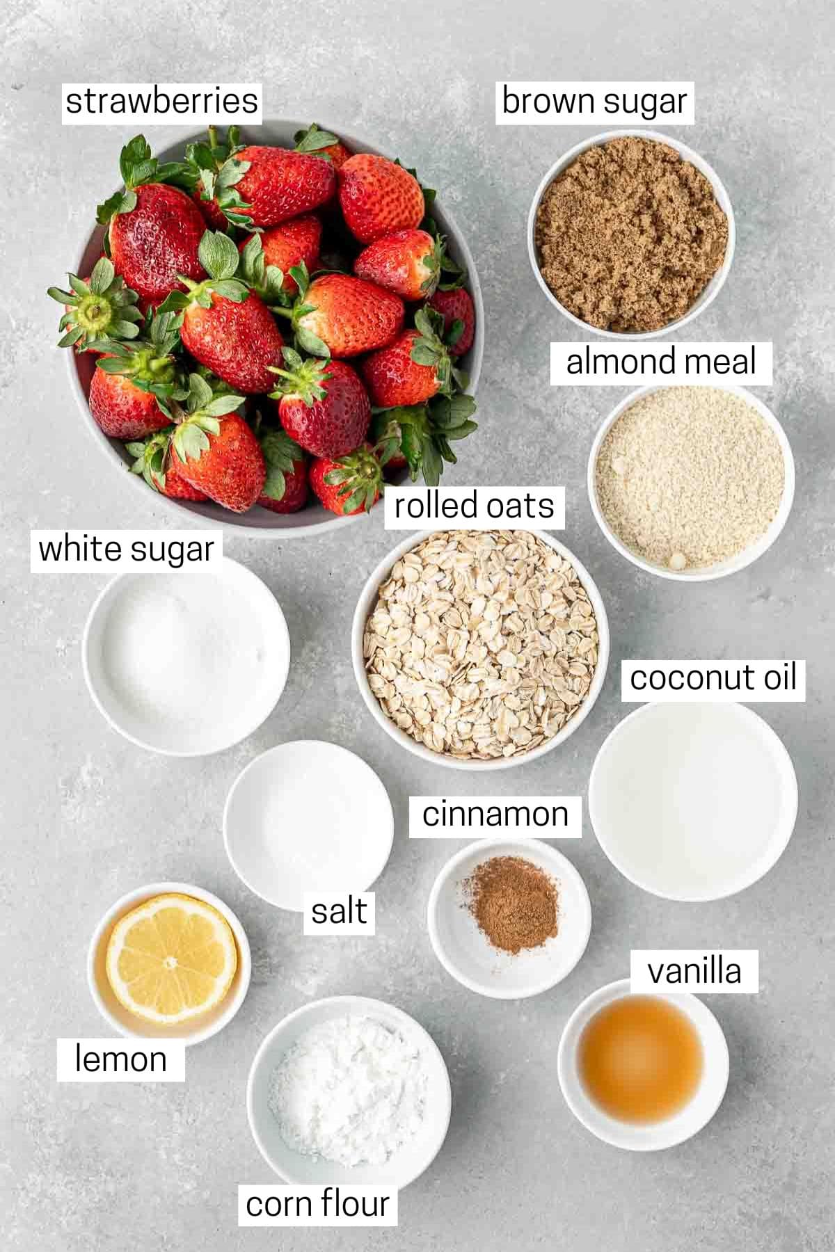 All ingredients needed to make strawberry crumble laid out in bowls.