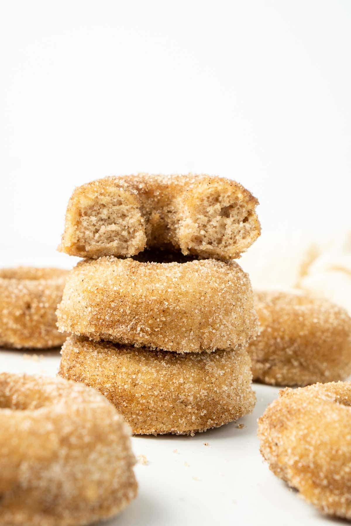 Three cinnamon doughnuts stacked on top of each other. 