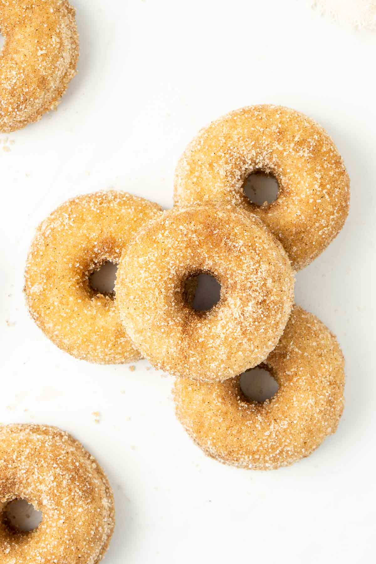 Four cinnamon sugar doughnuts stacked on top of each other from above.