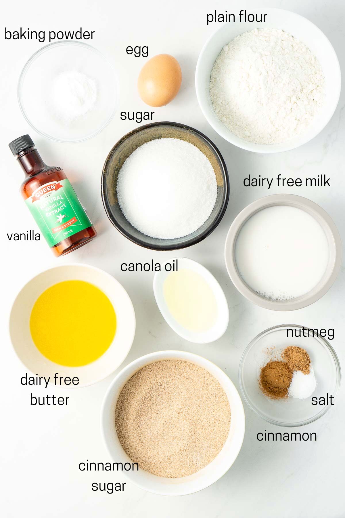 All ingredients needed for cinnamon sugar doughnuts laid out in small bowls.