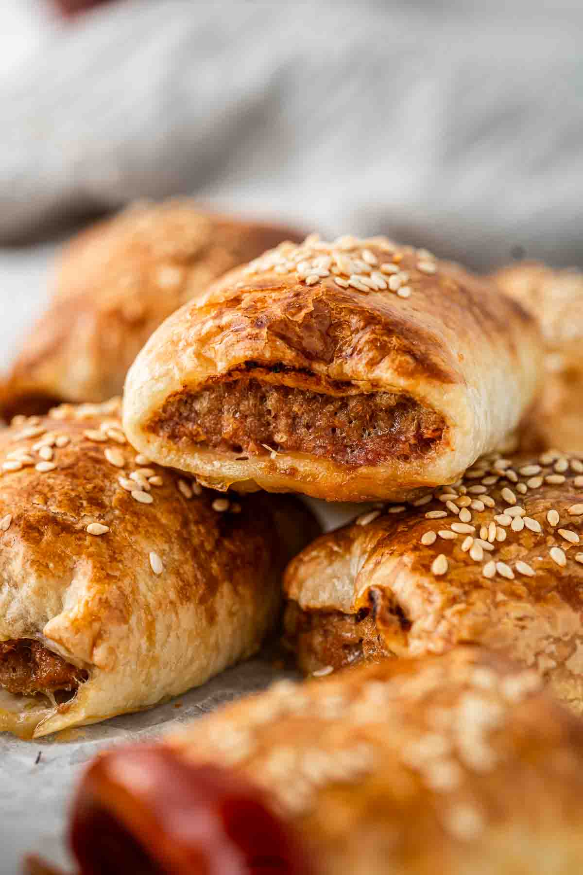 Close up of sausage rolls topped with sesame seeds.