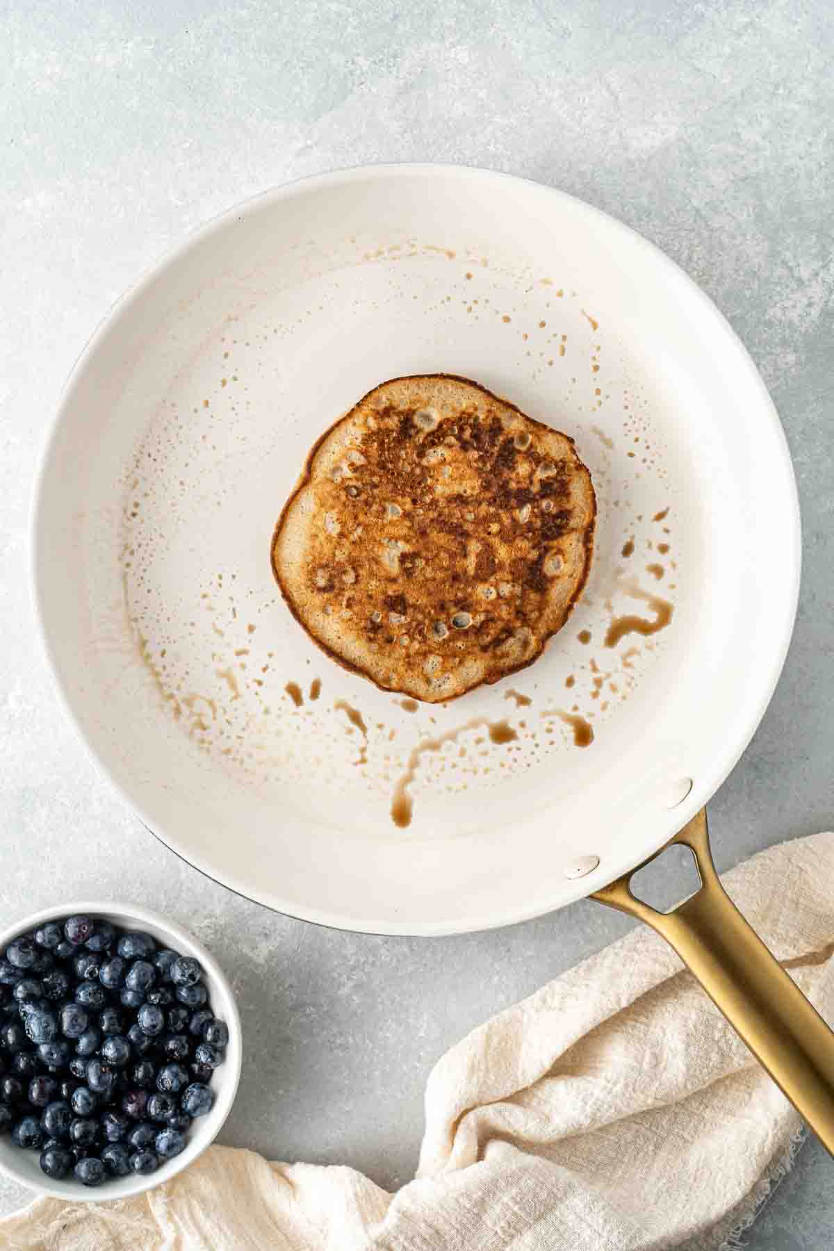 Flipped pancake in a frying pan.