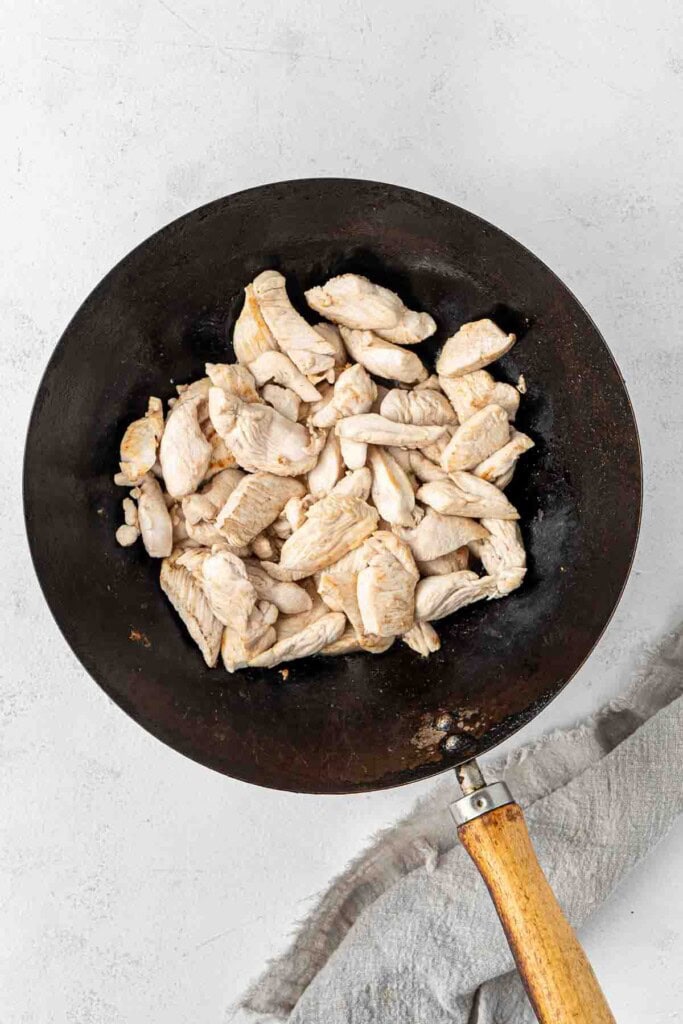 Stir frying chicken in a wok.