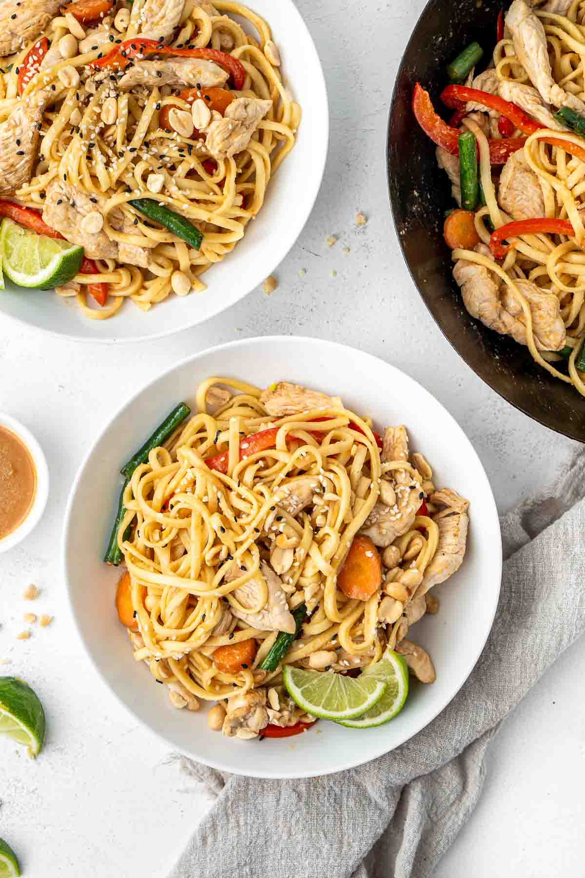 Chicken satay noodles in white bowls.