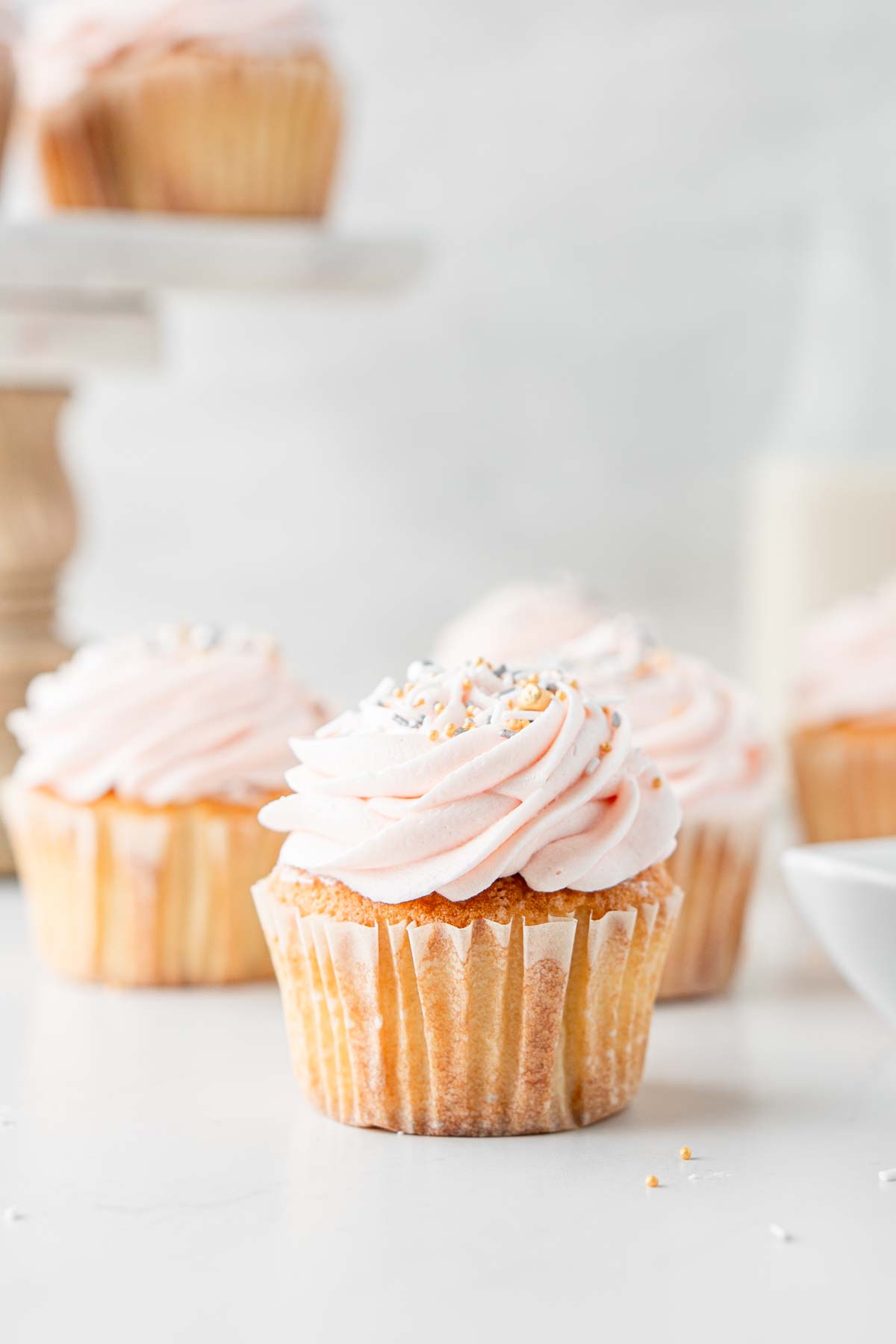 Close up of vanilla cupcakes with sprinkles.